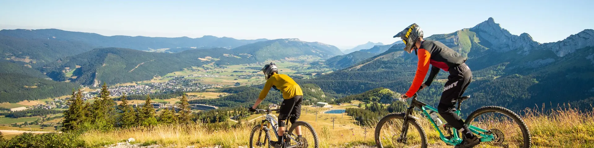 Due ciclisti in tenuta da competizione che scalano un pendio roccioso in montagna