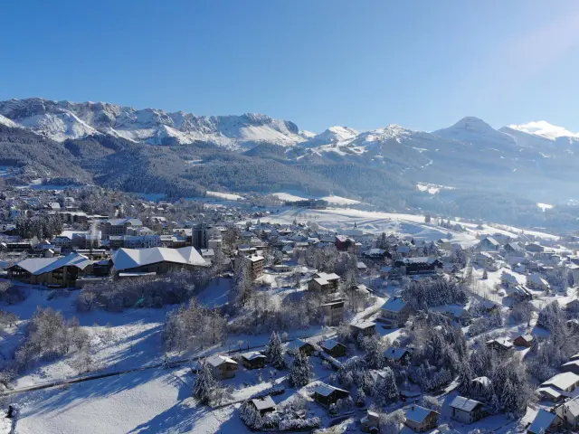 Village de montagne entouré de sommets enneigés au crépuscule