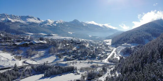 Vista aerea di una valle innevata con montagne sullo sfondo