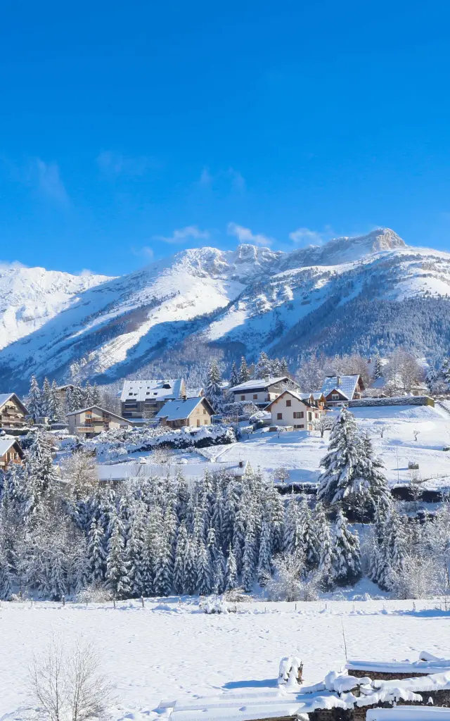 Stazione sciistica innevata con impianti di risalita e cime innevate