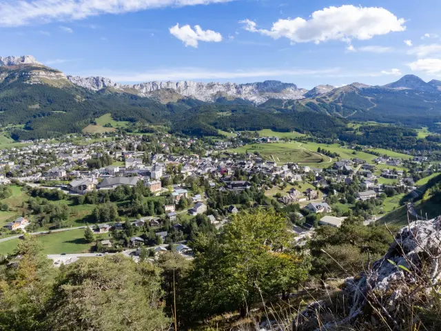 Colline verdi con vigneti a terrazze e case sparse sotto un cielo blu chiaro