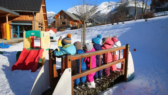 Enfants souriants dans un igloo décoré de motifs colorés enneigé