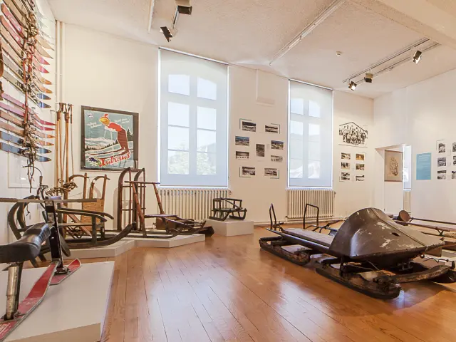 Intérieur d’un salon avec canapé en cuir, table basse en bois, bibliothèque et grandes baies vitrées donnant sur la mer