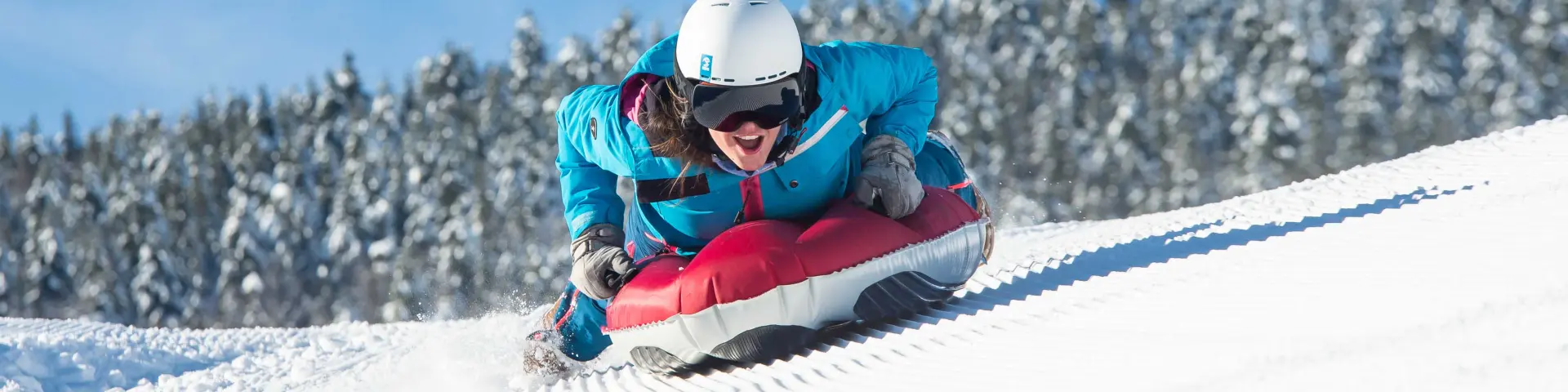 Skieuse en combinaison bleue et rouge glissant sur une pente enneigée
