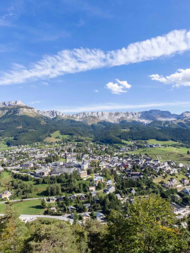 Village de montagne entouré de collines verdoyantes et de bâtiments dispersés