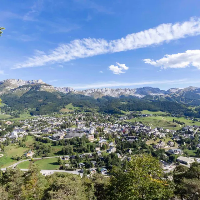 Village de montagne entouré de collines verdoyantes et de bâtiments dispersés