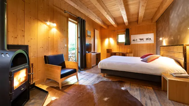 Spacious hotel room with double bed, sofa, coffee table, and sea view through a large window