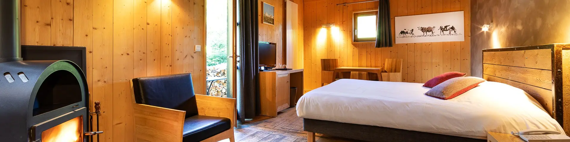 Camera d’albergo spaziosa con letto matrimoniale, divano, tavolino e vista mare attraverso una vetrata