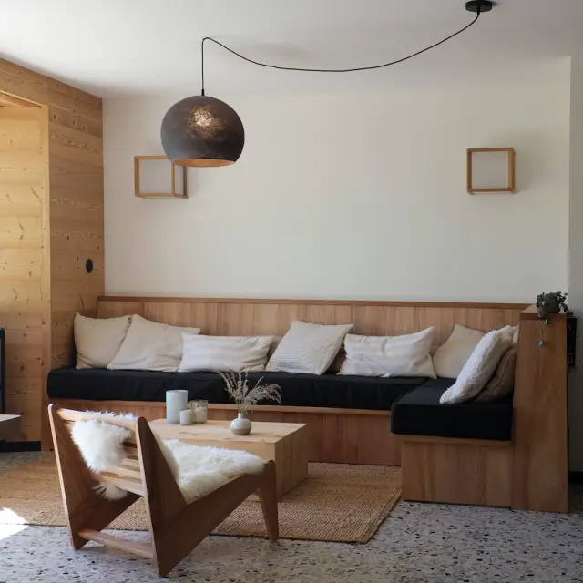 Salotto contemporaneo con divano in tessuto beige, tavolino in legno e vista su un mare calmo