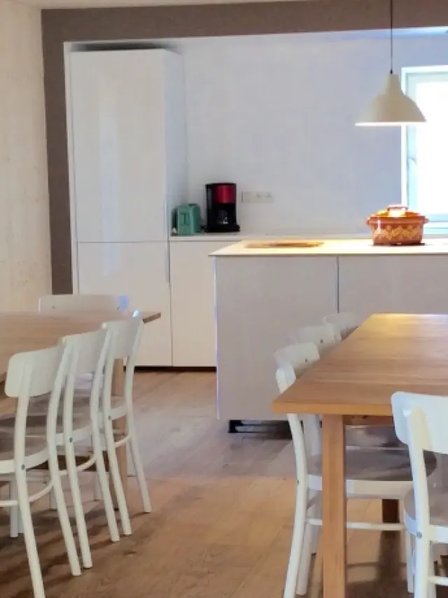 Cucina attrezzata con isola centrale, sgabelli e elettrodomestici bianchi