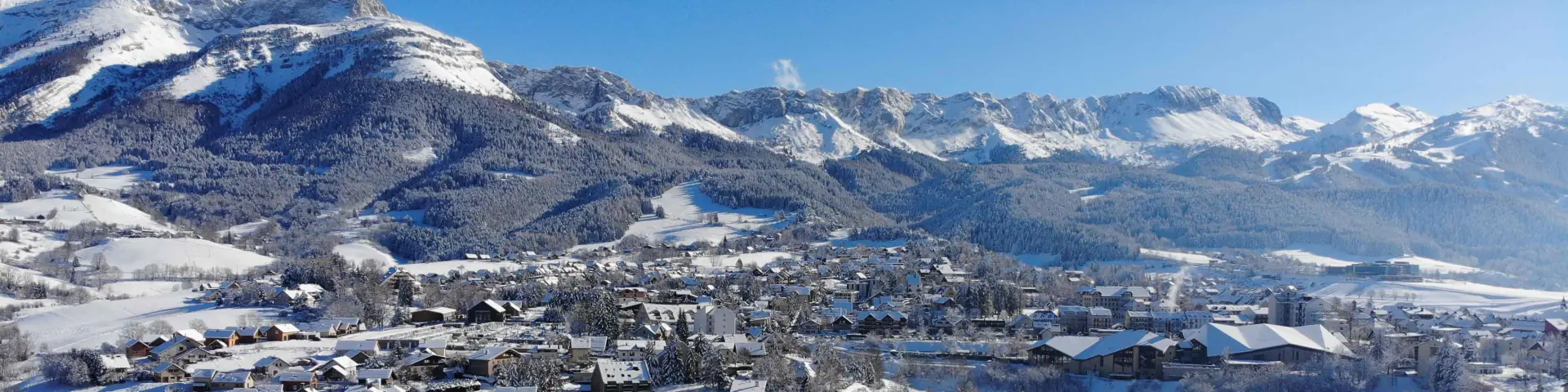 Village enneigé entouré de montagnes en hiver