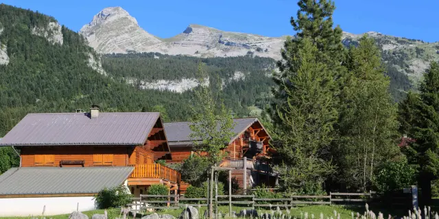 Port de montagne avec des voiliers amarrés, des bâtiments en bois et des montagnes enneigées en arrière-plan