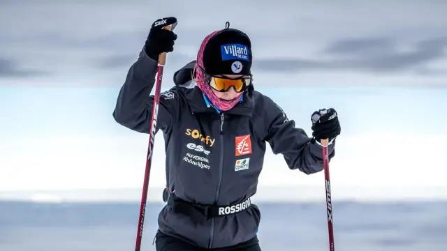 Skieuse en tenue de compétition avec numéros 5049 et 12, tenant ses bâtons