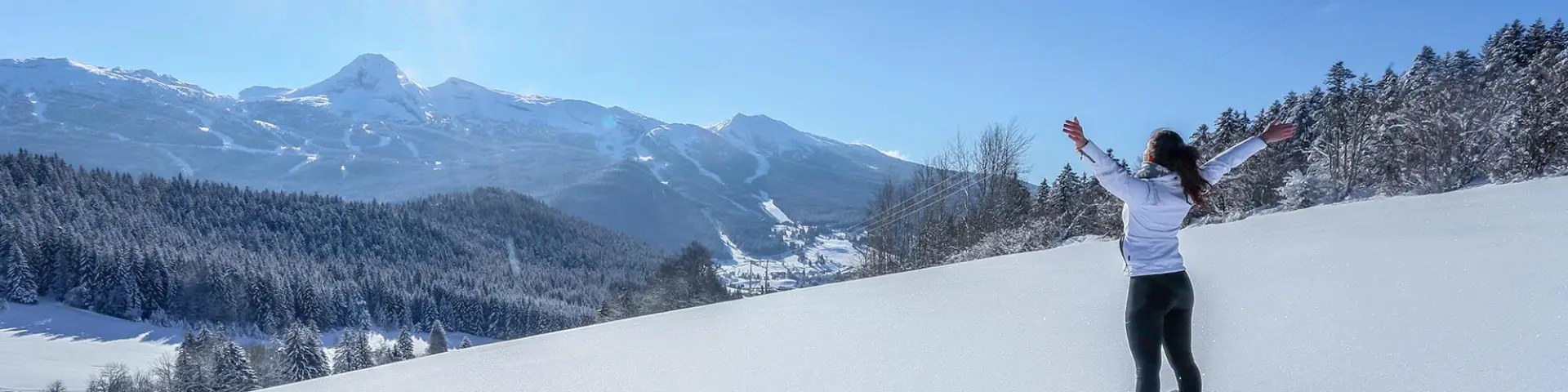 Sciatore in tenuta nera che scende una pista da sci innevata