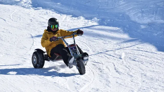 Motociclista in tuta gialla e casco nero che guida un veicolo fuoristrada sulla neve