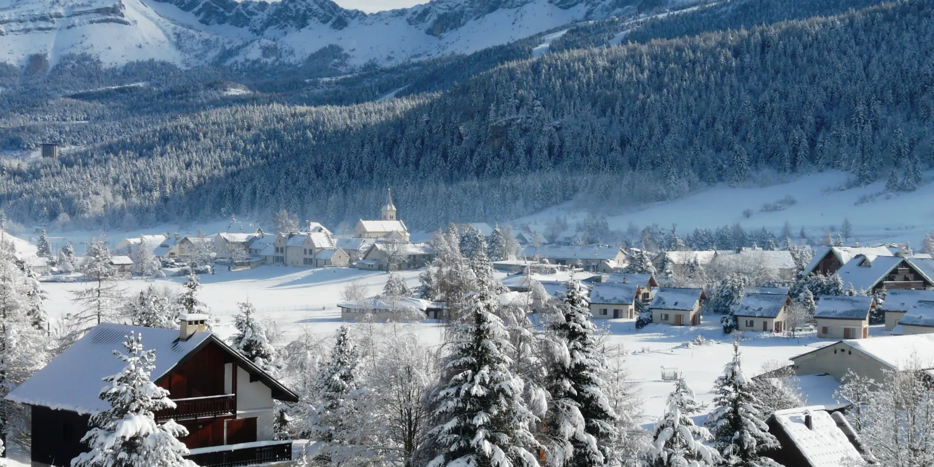 Porto di montagna coperto di neve con edifici e barche a vela ormeggiate
