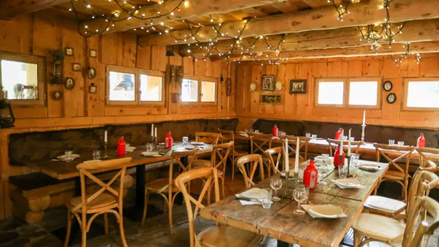 Interno di un ristorante con tavoli in legno, sedie e lampadari sospesi