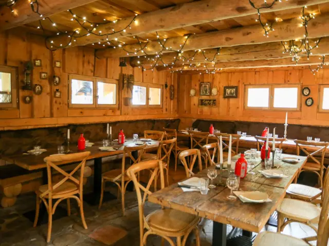 Intérieur d'un restaurant avec tables en bois, chaises et luminaires suspendus