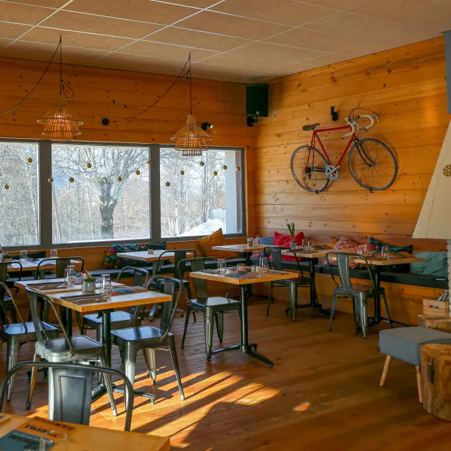 Salle de réunion équipée de tables en bois, chaises et écrans blancs, avec vue sur des voiliers amarrés dans un port