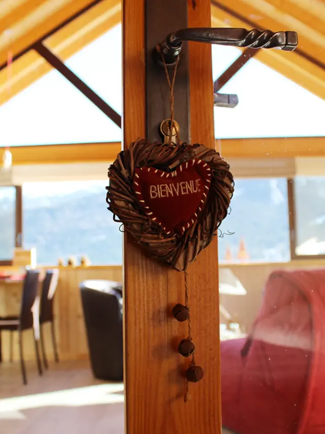 Cartello in legno appeso che indica BENVENUTO con lettere intagliate
