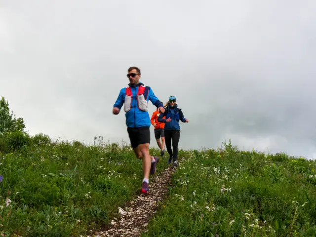 Due persone in abbigliamento da escursionismo sotto la pioggia in montagna