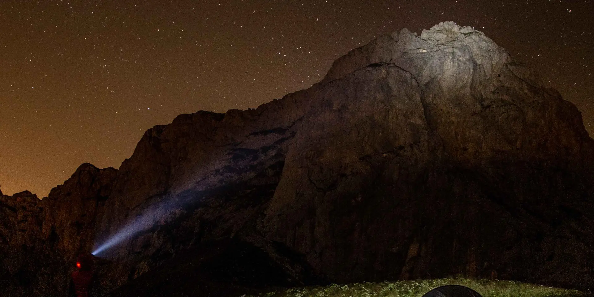 Montagna innevata sotto un cielo notturno costellato di stelle