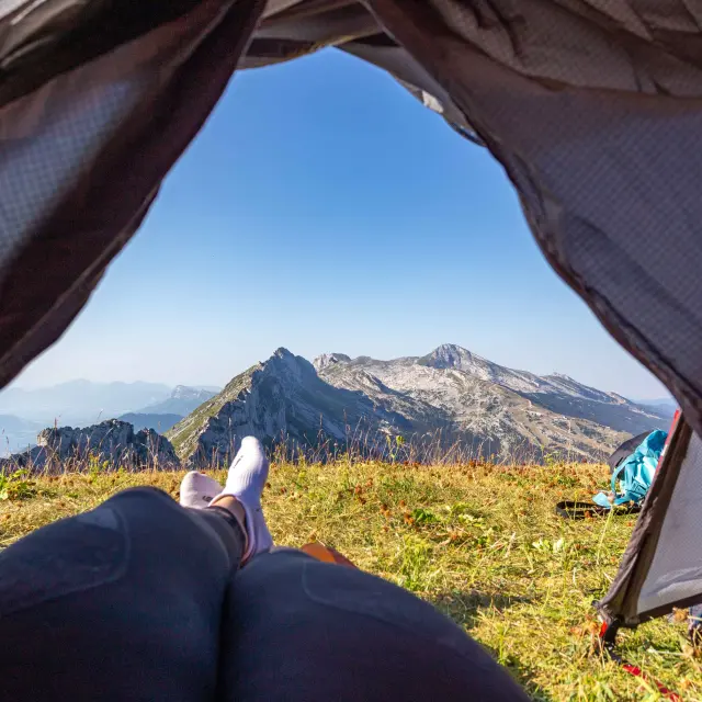 Tente de camping ouverte avec vue sur des montagnes en arrière-plan