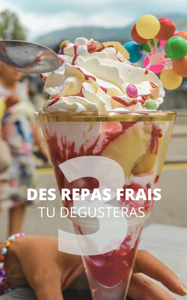 Cocktail servito in un bicchiere con cannuccia e fette di frutta fresca su un tavolo in terrazza