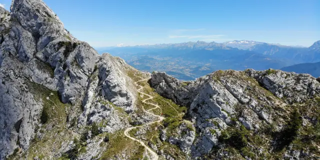 Catena montuosa scoscesa con rocce e pendii erbosi illuminati dalla luce del tramonto