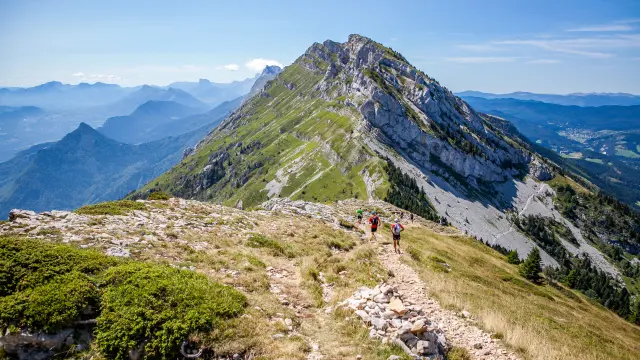 Paysage de montagne avec des sommets enneigés et des versants couverts de végétation