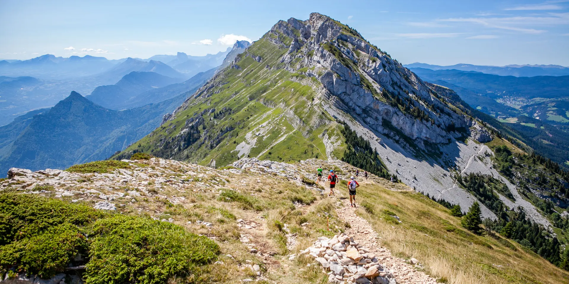 Paesaggio montuoso con cime innevate e versanti coperti di vegetazione