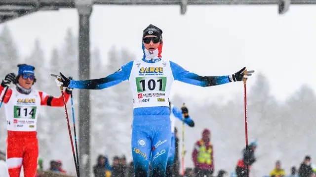 Sciatore in tenuta blu con pettorale 101 in competizione su pista da sci