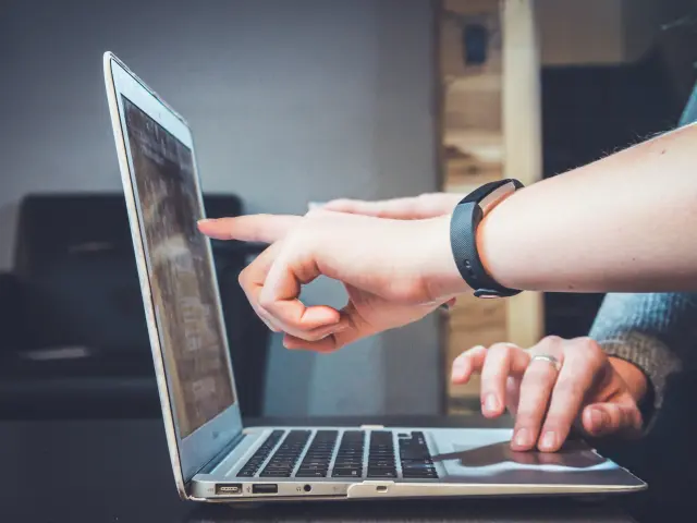 Main d’une personne utilisant un clavier adapté et une souris ergonomique sur un bureau