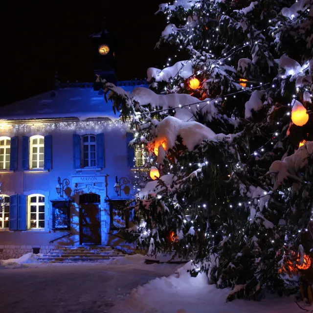 Casa a un piano con finestre illuminate e decorazioni luminose lungo una strada
