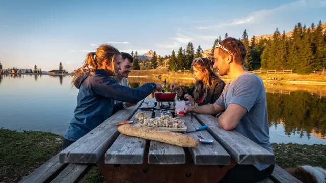 Deux personnes assises à une table en terrasse avec des boissons et des jeux de société