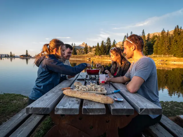 Two people sitting at a terrace table with drinks and board games
