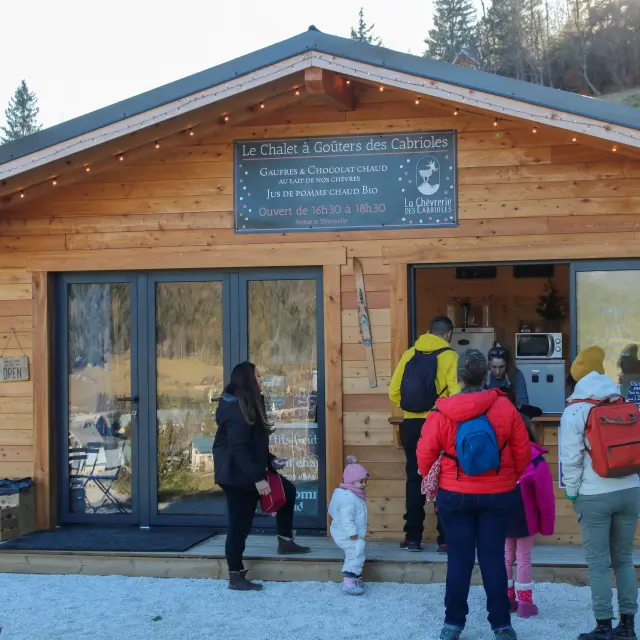 Facciata di un negozio di cioccolato artigianale chiamato Le Chalet à Goûters des Cabrioles, con clienti davanti all’ingresso