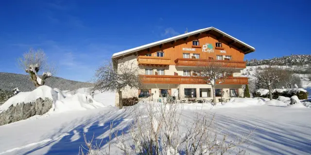 Stazione sciistica con edifici in legno e piste innevate, circondata da montagne