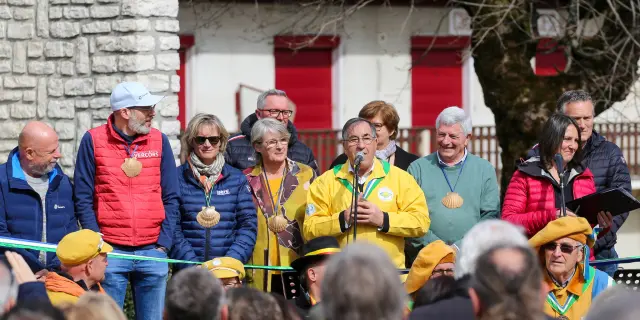 Groupe de personnes en combinaison de travail jaune et casque de sécurité, sur un quai près de bateaux
