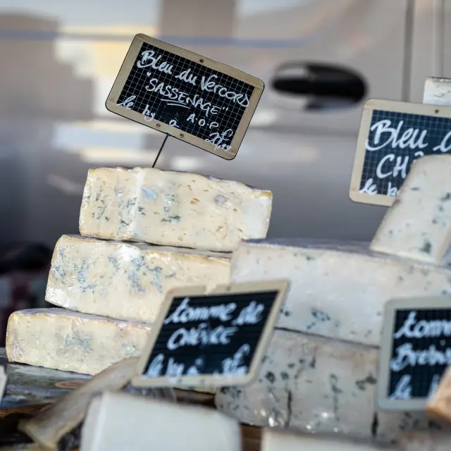 Fromages affinés posés sur des planches en bois avec des étiquettes indiquant leur nom