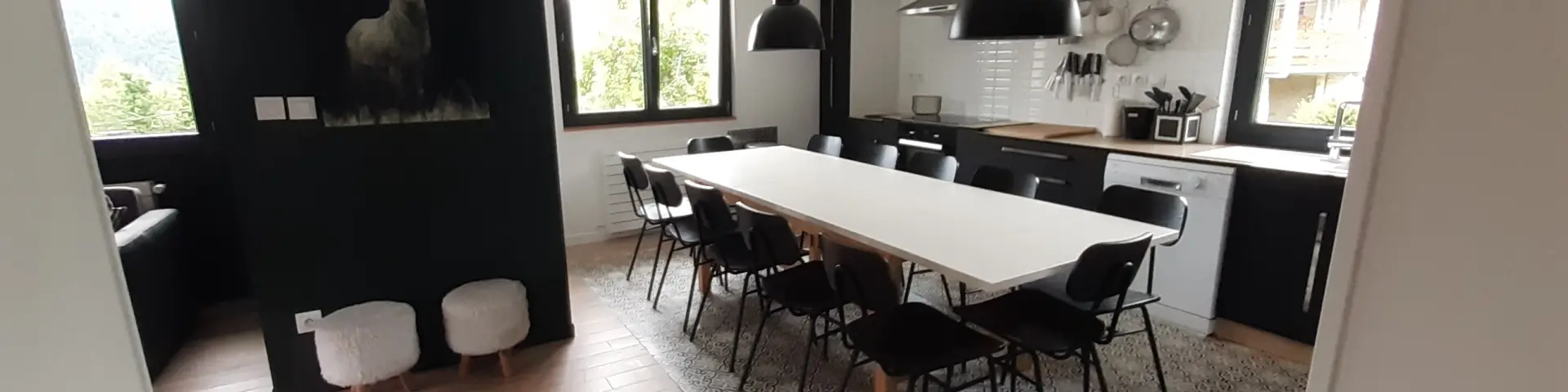 Bureau contemporain avec écrans d'ordinateur, chaise ergonomique et vue sur la mer à travers une baie vitrée