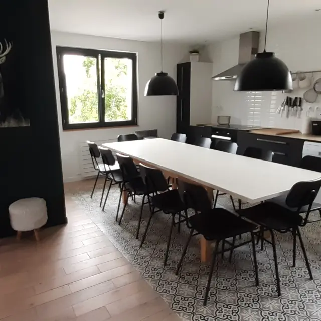 Bureau contemporain avec écrans d'ordinateur, chaise ergonomique et vue sur la mer à travers une baie vitrée