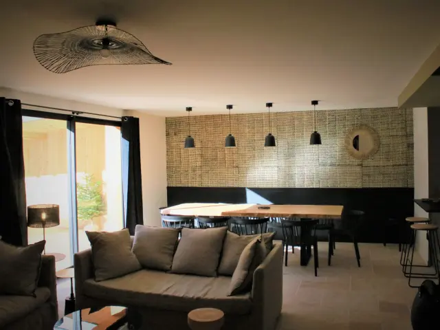 Salon contemporain avec canapé en cuir, table basse et vue sur une baie vitrée donnant sur la mer