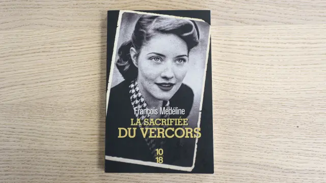 Portrait en noir et blanc d’une femme avec une écharpe à motifs, portant un chapeau et une veste