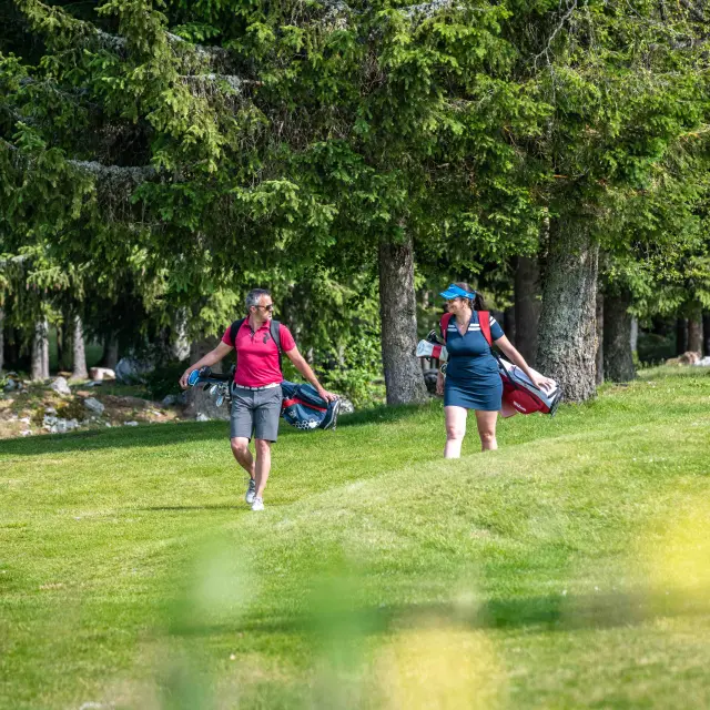 Deux jeunes lancent un frisbee dans un parc verdoyant