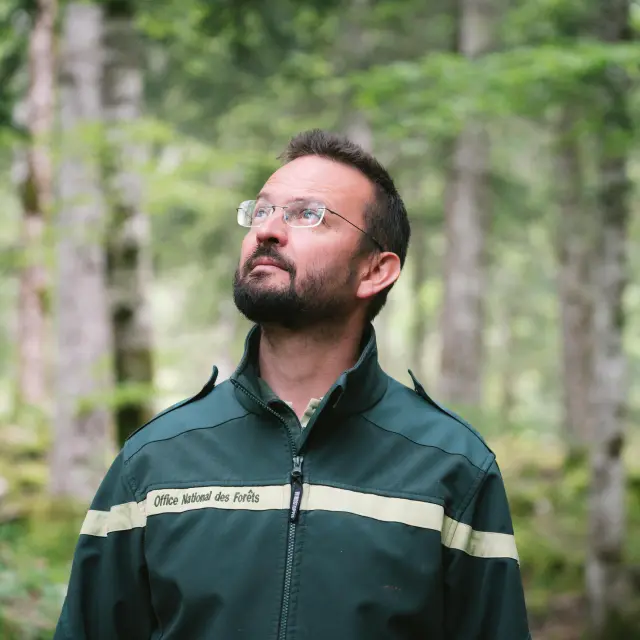 Agent forestier en uniforme avec badge et écusson, debout en extérieur