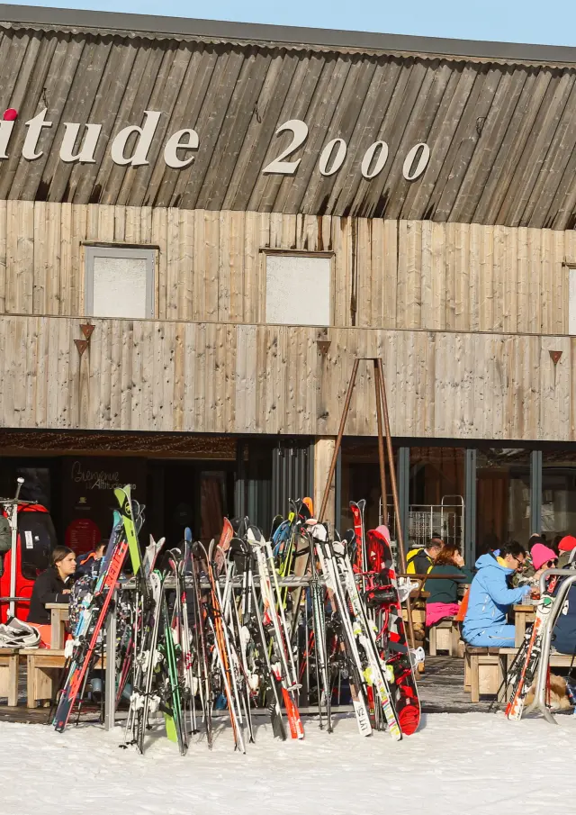 Défilé de mode avec des mannequins présentant des vêtements devant un bâtiment en bois