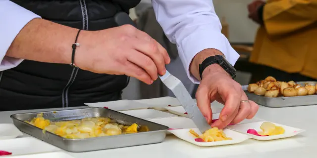 Deux personnes préparant des desserts dans une cuisine professionnelle, avec des ingrédients et des moules en silicone