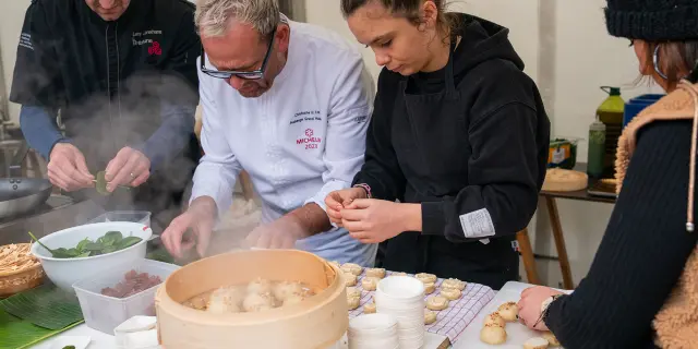 Participants à un atelier culinaire préparant des crêpes sur une plaque chauffante
