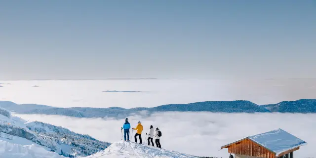 Gruppo di escursionisti in montagna con un rifugio sullo sfondo